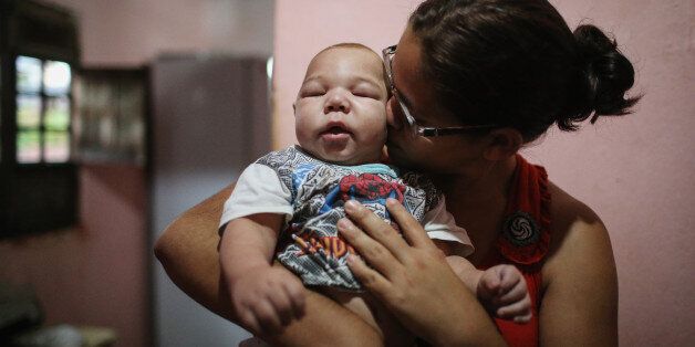RECIFE, BRAZIL - JANUARY 29: David Henrique Ferreira, 5 months, who was born with microcephaly, is kissed by his mother Mylene Helena Ferreira on January 29, 2016 in Recife, Pernambuco state, Brazil. In the last four months, authorities have recorded around 4,000 cases in Brazil in which the mosquito-borne Zika virus may have led to microcephaly in infants. The ailment results in an abnormally small head in newborns and is associated with various disorders including decreased brain development. According to the World Health Organization (WHO), the Zika virus outbreak is likely to spread throughout nearly all the Americas. (Photo by Mario Tama/Getty Images)