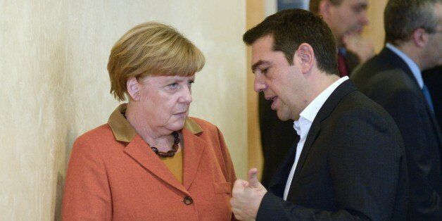 Greek Prime Minister Alexis Tsipras (R) speaks to German Chancellor Angela Merkel ahead of an EU-Balkans mini summit at the EU headquarters in Brussels on October 25, 2015. European Union and Balkan leaders faced a make-or-break summit on the deepening refugee crisis after three frontline states threatened to close their borders if their EU peers stopped accepting migrants. AFP PHOTO / JOHN THYS (Photo credit should read JOHN THYS/AFP/Getty Images)