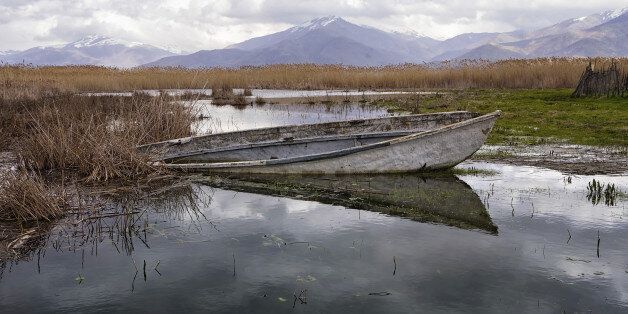 Old and semi sunken wooden boat in Prespa lake, Florina, Greece, in autumn