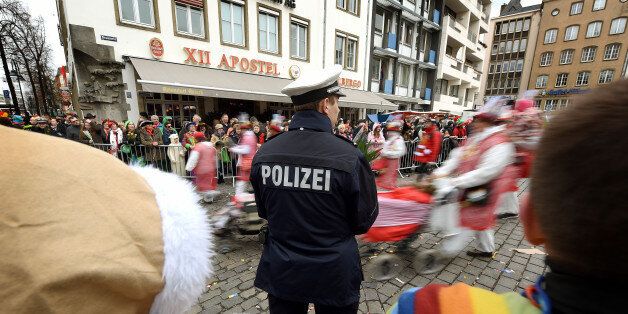 COLOGNE, GERMANY - FEBRUARY 07: A Police officer stands between Carnival revellers during a carnival parade called 'Schull- un Veedelszoech' as part of the carnival season on February 7, 2016 in Cologne, Germany. Carnival partying and parades, a centuries-old tradition in western and southwestern Germany, traditionally occurs in February and runs until Ash Wednesday, the start of Lent, and culminates in Rose Monday parades and festivities. Police are on added alert this year, particularly in Col