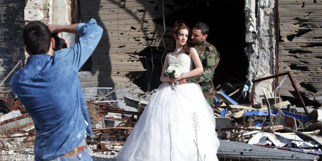 Newly-wed Syrian couple Nada Merhi,18, and Hassan Youssef,27, have their wedding pictures taken in front of a heavily damaged building in the war ravaged city of Homs on February 5, 2016.A Syrian photographer thought of using the destruction of Homs to take pictures of newly wed couples to show that life is stronger than death. / AFP / JOSEPH EID (Photo credit should read JOSEPH EID/AFP/Getty Images)