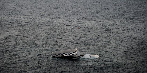 A boat that capsized is seen on January 31, 2016 in Canakkale's Bademli district after at least 37 migrants drowned when their boat sank in the Aegean Sea while trying to cross from Turkey to Greece, Turkey's state-run Anatolia news agency reported. The migrants, some from Syria, others from Afghanistan and Myanmar, set sail from the Canakkale province to reach the nearby Greek island of Lesbos, Anatolia said. / AFP / OZAN KOSE (Photo credit should read OZAN KOSE/AFP/Getty Images)