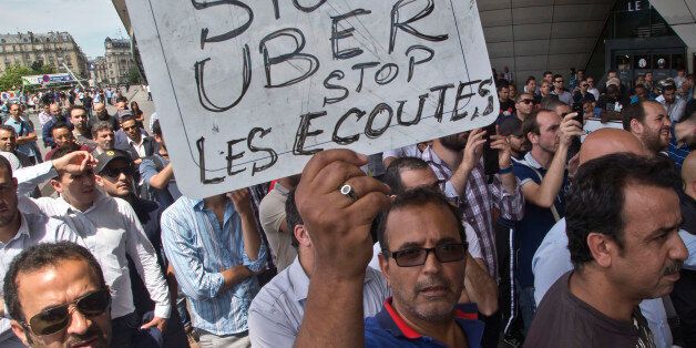 A striking taxi driver holds a placard which read,
