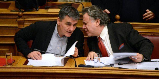 ATHENS, GREECE - 2016/01/26: Minister of Finance Euclid Tsakalotos (l) talks with Minister of Labour, Social Insurance and Social Solidarity Georgios Katrougalos (r). Greek lawmakers discuss the planned Pension Reforms in the Greek parliament after Greek Prime Minister asked for the opinions of the oposition partys. (Photo by George Panagakis/Pacific Press/LightRocket via Getty Images)