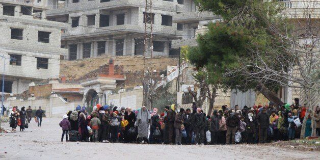 Residents of the besieged rebel-held Syrian town of Madaya wait for a convoy of aid from the Syrian Arab Red Crescent on January 14, 2016.The convoy of about 50 aid trucks left Damascus for the hunger-stricken Syrian town of Madaya where 40,000 residents have suffered a crippling government siege that has drawn sharp condemnation from the United Nations. / AFP / LOUAI BESHARA (Photo credit should read LOUAI BESHARA/AFP/Getty Images)