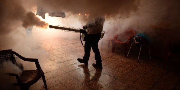 TOPSHOT - A Health Ministry employee fumigates a home against the Aedes aegypti mosquito to prevent the spread of the Zika virus in Soyapango, six km east of San Salvador, on January 21, 2016. Health authorities have issued a national alert against the Aedes Aegypti mosquito, because of the link between the Zika virus and microcephaly and Guillain-BarrÃ© Syndrome in fetuses. AFP PHOTO/Marvin RECINOS / AFP / Marvin RECINOS (Photo credit should read MARVIN RECINOS/AFP/Getty Images)