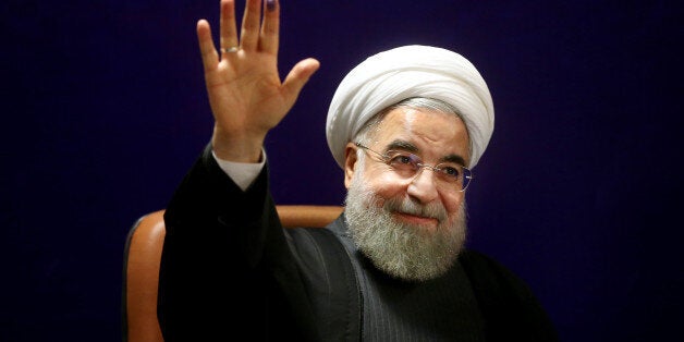 Iran's President Hassan Rouhani, who is also a member of the Experts Assembly, waves to media with an ink-stained finger, after registering his candidacy for the Feb. 26 elections of the assembly at interior ministry in Tehran, Iran, Monday, Dec. 21, 2015. (AP Photo/Ebrahim Noroozi)