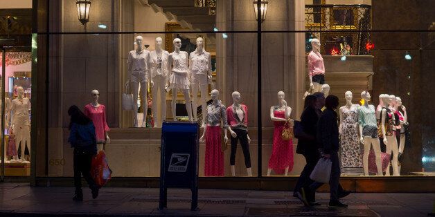Shoppers walk past a Juicy Couture Inc. store on 5th Avenue in New York, U.S., on Tuesday, April 8, 2014. Consumer Comfort figures are scheduled to be released on April 10. Photographer: Craig Warga/Bloomberg via Getty Images
