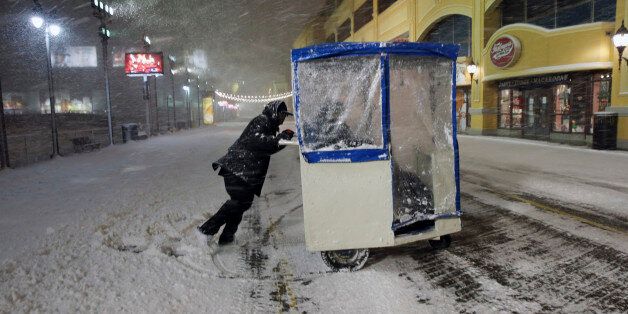 A man maneuvers his Push cart with passengers during a snowstorm early Saturday, Jan. 23, 2016, on the Atlantic City Boardwalk. Most of the state was facing a blizzard warning from Friday evening until Sunday that called for up to 24 inches of snow, with the deepest accumulations in the central part of the state. (AP Photo/Mel Evans)