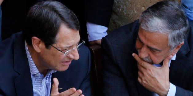 Cyprus President Nicos Anastasiades, left, and Turkish Cypriot leader Mustafa Akinci, speak as they sit at a coffee shop at the Turkish Cypriot breakaway northern part of the Cypriot divided capital Nicosia on Saturday, May 23, 2015. Cyprusâ rival Greek and Turkish Cypriot leaders took a stroll together on both sides of the divided capitalâs medieval center to raise the feel-good factor as talks aimed at reunifying the ethnically split island kick into gear. Itâs the first time that the leaders have done so together since the east Mediterranean island was split in 1974 when Turkey invaded after coup by supporters of union with Greece. (AP Photo/Petros Karadjias)