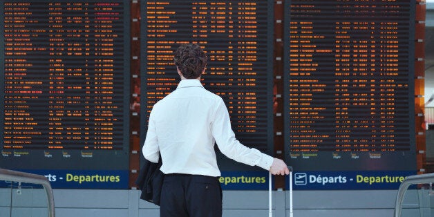 passenger looking at timetable board at the airport