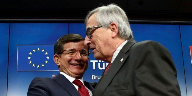 BRUSSELS, BELGIUM - NOVEMBER 29: Turkish Prime Minister Ahmet Davutoglu (L) hugs European Commission president Jean-Claude Juncker during a press conference at the end of a summit on relations between the European Union and Turkey at the European Council in Brussels on November 29, 2015 (Photo by Mehmet Kaman/Anadolu Agency/Getty Images)