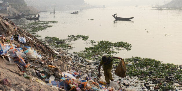 Ten year-old Bangladesh girl Sharmin, sifts through refuse in search for plastic that she can sell for recycling by a riverside in Dhaka on January 3, 2014. Sharmin lives in poverty as do a third of the 140 million people living in Bangladesh. More than three-quarters of Bangladeshis are opposed to this weekend's general election which is being boycotted by the main opposition, a poll showed. AFP PHOTO/Roberto SCHMIDT (Photo credit should read ROBERTO SCHMIDT/AFP/Getty Images)