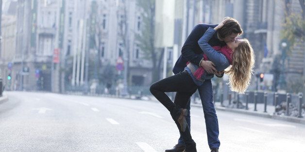 Young couple kissing in a middle of a city road.