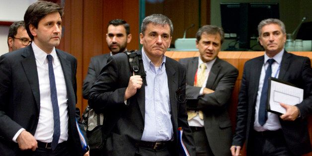 Greece's Finance Minister Euclid Tsakalotos, center, arrives for a meeting of eurogroup finance ministers at the EU Council building in Brussels on Thursday, Jan. 14, 2016. Finance ministers from the nations using the euro met in Brussels Thursday to discuss progress on Greeceâs economic reform program and the results of a review of measures taken by Cyprus to bring its budget into line.(AP Photo/Virginia Mayo)