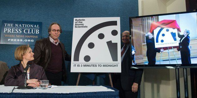 Lawrence Krauss (2nd L), chair of the Bulletin of Atomic Scientists' Board of Sponsors stands by the 'Doomsday Clock' showing that the world is now three minutes away from catastrophe as scientists at Stanford University in California unveil theirs during a joint press conference of the Bulletin of Atomic Scientists in Washington, DC, on January 26, 2016. On left, is Sharon Squassoni, member of the Bulletin's Science and Security Board, and standing behind the clock is former US ambassador to the UN and current member of the Bulletin's Science and Security Board Thomas Pickering. / AFP / Nicholas Kamm (Photo credit should read NICHOLAS KAMM/AFP/Getty Images)