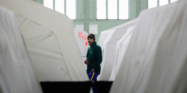 A migrant walks through Hanger 1 of the former airport Tempelhof packed with tents as a temporary emergency...