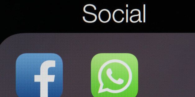 Icons for the WhatsApp Inc. mobile-messaging application WhatsApp and the Facebook Inc. application are displayed in a social media folder on the screen of an Apple Inc. iPhone in this arranged photograph taken in London, U.K., on Thursday, Feb. 20, 2014. Facebook, the worlds largest social network, agreed to acquire mobile-messaging startup WhatsApp Inc. for as much as $19 billion in cash and stock, seeking to expand its reach among users on mobile devices. Photographer: Chris Ratcliffe/Bloombe