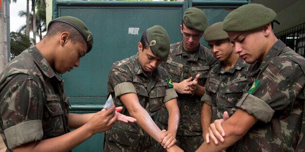 Army soldiers apply insect repellent as they prepare for a clean up operation against the Aedes aegypti mosquito, which is a vector for transmitting the Zika virus in Sao Paulo, Brazil, Wednesday, Jan. 20, 2016. A U.S. warning urging pregnant women to avoid travel to Latin American countries where the mosquito-borne virus is multiplying threatens to depress tourism to the region, one of its few bright spots at a time of deep economic pain. (AP Photo/Andre Penner)