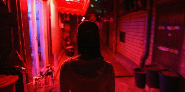 SEOUL, SOUTH KOREA - OCTOBER 19: A South Korean prostitute walks into her place of business on October 19 2004, in Seoul, South Korea. The South Korean government began enforcing new laws last month to target human traffickers, pimps and prostitutes. The sex industry accounts for more than four percent of South Korea's gross domestic product (GDP), with its annual sales estimated at 24 trillion won (21 billion dollars) last year. Statistics show one in five South Korean men buy sex four times a month and 4.1 percent of women aged 20 to 30 rely on prostitution to make a living. (Photo by Chung Sung-Jun/Getty Images)