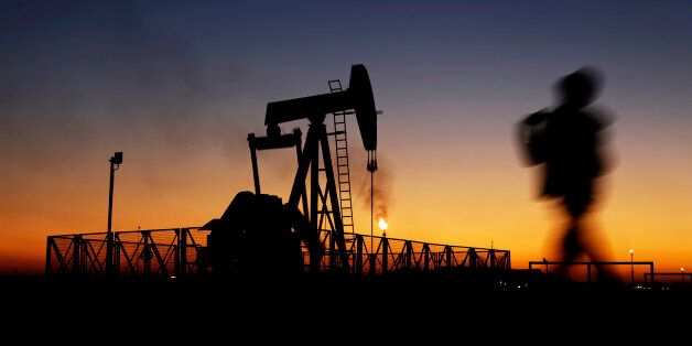 A boy walks by an oil pump at sunset Monday, Jan. 18, 2016, in the desert oil fields of Sakhir, Bahrain. Iran is aiming to increase its oil production by 500,000 barrels per day now that sanctions have been lifted under a landmark nuclear deal with world powers, a top official said. (AP Photo/Hasan Jamali)
