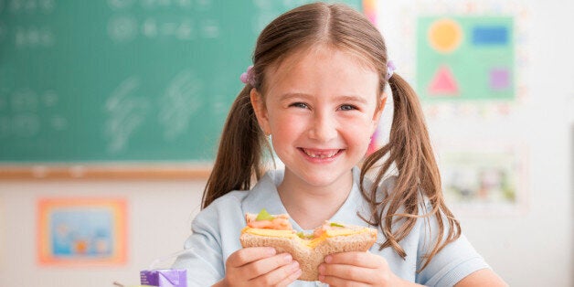 Caucasian student eating lunch in classroom