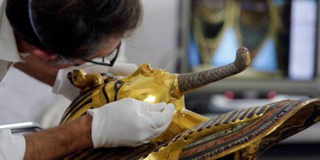 German restorer Christian Eckmann begins restoration work on the golden mask of King Tutankhamun over a year after the beard was accidentally broken off and hastily glued back with epoxy, at the Egyptian Museum in Cairo, Egypt, Tuesday, Oct. 20, 2015. The 3,300-year-old burial pharaonic mask was discovered in Tutankhamun's tomb along with other artifacts by British archeologists in 1922, sparking worldwide interest in archaeology and ancient Egypt. (AP Photo/Amr Nabil)