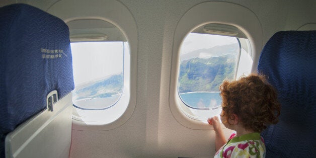 Little girl looking out an airplane window.