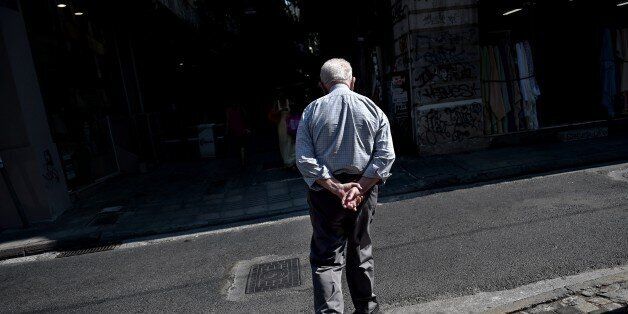 An elderly man walks in central Athens on July 14, 2015. Greek Prime Minister Alexis Tsipras was holding meetings with his party, faced with the tough task of selling a new bailout deal that requires Athens to push through draconian reforms within two days. AFP PHOTO / ARIS MESSINIS (Photo credit should read ARIS MESSINIS/AFP/Getty Images)