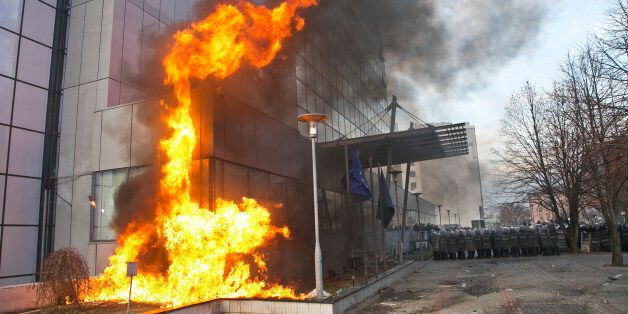 Supporters of the opposition throw molotov cocktails at the government building in Kosovo capital Pristina on Saturday, Jan. 9, 2016. A government building was set on fire in Pristina on Saturday as supporters of Kosovo's main opposition parties gathered during a rally organised as part of their continued attempts to bring down the government. Security forces used tear gas to push back protesters. (AP Photo/Visar Kryeziu)