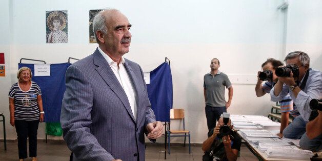 Evangelos Meimarakis, leader of the New Democracy Party of Greece, reacts as he places his voting slip in a ballot box as he votes in the general election in the suburb of Marousi, Athens, Greece, on Sunday, Sept. 20, 2015. Greeks began voting Sunday in a general election to determine who will lead efforts to implement European bailout agreements and restore economic normalcy to the continents most indebted country. Photographer: Yorgos Karahalis/Bloomberg via Getty Images