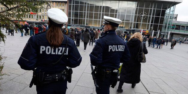 Police officers survey the area in front of the main train station and the Cathedral in Cologne, western...