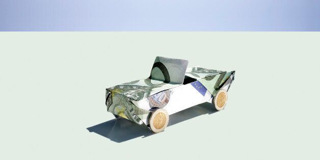 Origami car folded with 100 euro notes and coins