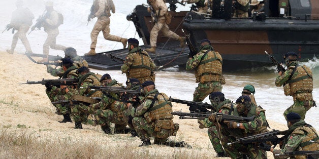 British Royal Marines and Portuguese fuzileiros, exit amphibious boats during the NATO Trident Juncture exercise 2015 in Troia, south of Lisbon, Thursday, Nov. 5, 2015. NATO Allies and partner nations join forces during three weeks for the Alliance's Trident Juncture live military exercise involving 36,000 troops from more than 30 nations across Portugal, Italy and Spain. (AP Photo/Steven Governo)