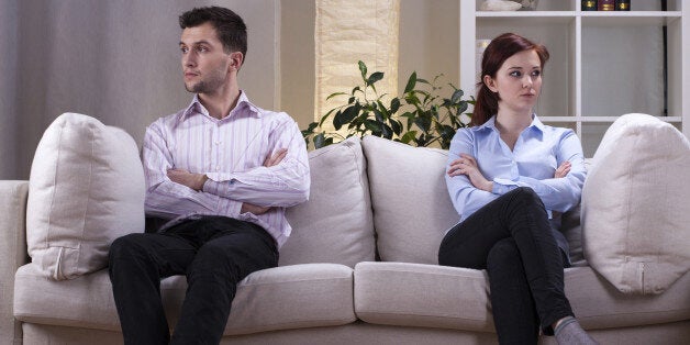 Young couple sitting on the sofa after quarrel