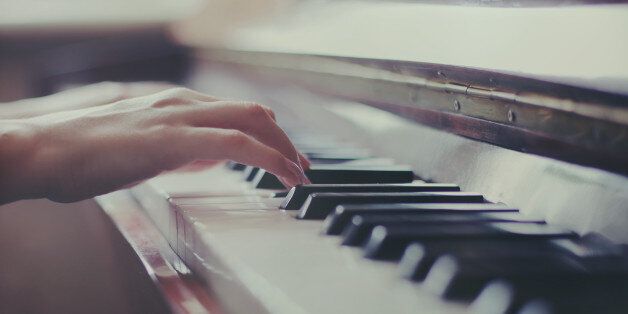 Female hands playing piano, close up.