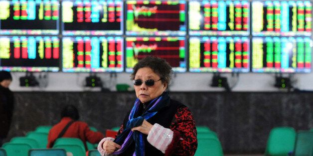 An investor makes her way in front of screens showing stock market movements in a stock firm in Wuhan, central China's Hubei province on January 8, 2016. China's short-lived stock circuit breaker, scrapped after only four days, demonstrates the communist state's enduring distrust of the markets and its instinct to intervene, analysts said on January 8. AFP PHOTO CHINA OUT / AFP / STR (Photo credit should read STR/AFP/Getty Images)