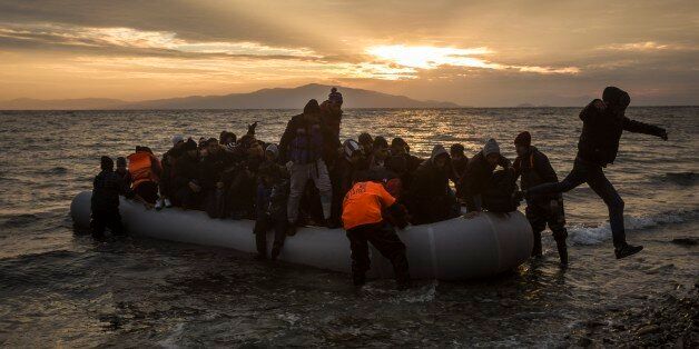 Refugees and migrants disembark on a beach after crossing a part of the Aegean sea from the Turkey's coast to the northeastern Greek island of Lesbos, on Sunday, Jan. 3, 2016. More than a million people reached Europe in 2015 in the continent's largest refugee influx since the end of World War II. Nearly 3,800 people are estimated to have drowned in the Mediterranean last year, making the journey to Greece or Italy in unseaworthy vessels packed far beyond capacity. (AP Photo/Santi Palacios)