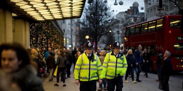 Police officers walk past the Selfridges department store as they patrol along Oxford Street in London, Tuesday, Dec. 22, 2015. There are two shopping days remaining until Christmas. (AP Photo/Matt Dunham)