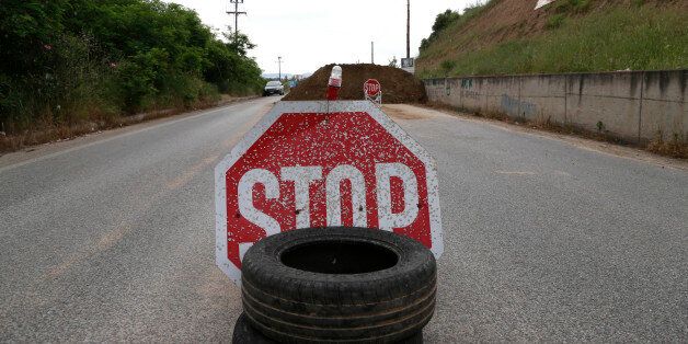 A Stop sign is placed at a barricade set up by residents at the village of Ierissos on the northern peninsula of Halkidiki, Greece, Monday, May 13 2013. Seven police officers were injured in weekend clashes in the area against plans to develop a gold mine by Canadian firm Eldorado Gold Corp. The officers were injured after an unidentified protester opened fire with a shotgun. (AP Photo/Dimitri Messinis)