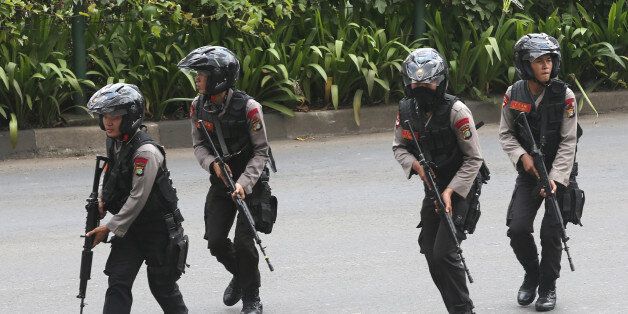 Police officers rush to take their position at the site of an attack in Jakarta, Indonesia Thursday, Jan. 14, 2016. Attackers set off explosions at a Starbucks cafe in a bustling shopping area in Indonesia's capital and waged gunbattles with police Thursday, leaving bodies in the streets as office workers watched in terror from high-rise buildings. (AP Photo/Tatan Syuflana)