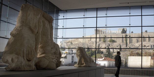 ATHENS, GREECE - OCTOBER 14: Visitors to Athens' Acropolis Museum look at the frieze of the Temple of Parthenon on October 14, 2014 in Athens, Greece. Lawyers Geoffrey Robertson and Amal Alamuddin are on a four-day visit to meet with government officials and advise on the return of the Parthenon Marbles, also known as the Elgin Marbles. Alamuddin's husband, actor George Clooney, campaigned for the Marbles' return when promoting his film 'The Monuments Men'. (Photo by Milos Bicanski/Getty Images)