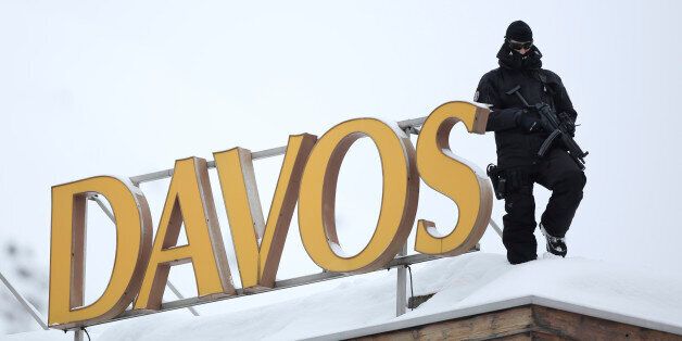 An armed police officer stands on the snow-covered rooftop of the Hotel Davos and looks out over the Congress Center, the venue for the World Economic Forum (WEF) in Davos, Switzerland, on Tuesday, Jan. 22, 2013. World leaders, Influential executives, bankers and policy makers arrive in the Swiss Alps for the 43rd annual meeting of the World Economic Forum in Davos, the five day event runs from Jan. 23-27. Photographer: Jason Alden/Bloomberg via Getty Images