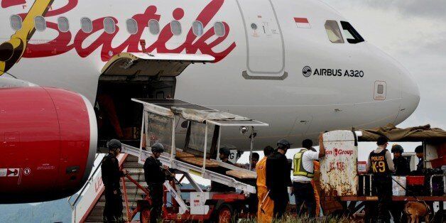 Indonesian bomb squad personnel use sniffer-dogs to inspect luggae on a Batik Air domestic airlines plane at Sultan Hasanuddin Airport in Makassar in South Sulawesi province on April 17, 2015. A passenger plane enroute from Ambon city to the Indonesian capital of Jakarta was forced to make an emergency landing in Makassar April 17, 2015, after air traffic control received a bomb threat, an official said, though police later confirmed it was a false alarm. AFP PHOTO / JALIN (Photo credit should read JALIN/AFP/Getty Images)