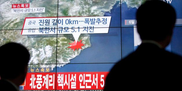 People walk by a screen showing the news reporting about an earthquake near North Korea's nuclear facility, in Seoul, South Korea, Wednesday, Jan. 6, 2016. South Korean officials detected an