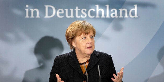 German Chancellor Angela Merkel delivers a speech during a reception at the chancellery in Berlin, Germany, Monday, Dec. 7, 2015 to mark the 60th. anniversary of the arrival of the first migrant workers in Germany. Slogan reads '60 Years of Migrant Workers in Germany'. (AP Photo/Michael Sohn)