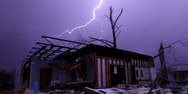 Lightning illuminates a house after a tornado touched down in Jefferson County, Ala., damaging several houses, Friday, Dec. 25, 2015, in Birmingham, Ala. A Christmastime wave of severe weather continued Friday. (AP Photo/Butch Dill)