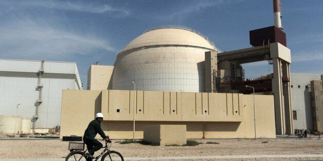 FILE - In this Oct. 26, 2010 file photo, a worker rides a bicycle in front of the reactor building of the Bushehr nuclear power plant, just outside the southern city of Bushehr. (AP Photo/Mehr News Agency, Majid Asgaripour, File)