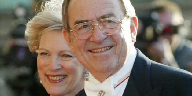 Former King Constantine of Greece and his wife Queen Anne Marie pass press photographers on their way to the Royal Theater in Copenhagen on Thursday, May 13, 2004. On the eve of the marriage of Denmark's Crown Prince Frederik and his Australian-born fiancee Mary Donaldson the royals attended a show featuring ballet, classical music, jazz and rock music. (AP Photo/Heribert Proepper)