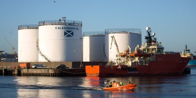 The Grampian Contender, a standby safety vessel, right, moves past oil storage silos operated by Caledonian Oil Ltd. on the quay-side at Aberdeen Harbour, operated by the Aberdeen Harbour Board, in Aberdeen, U.K. on Tuesday, Dec. 8, 2015. As Brent crude futures crashed through $40 a barrel Tuesday for the first time in almost seven years, analysts were still predicting average prices of $51 in the first quarter, according to data compiled by Bloomberg. Photographer: Simon Dawson/Bloomberg via Getty Images